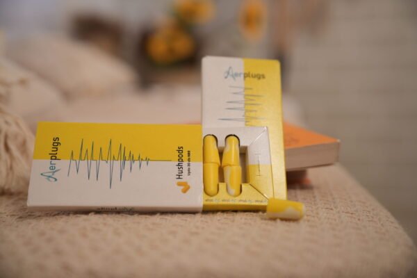 "HushPods by Aerplugs – yellow and white foam earplugs with up to 30 dB noise reduction for focus, travel, and sleep"